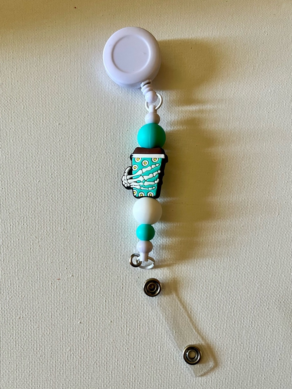 Turquoise and White Beaded Badge Reel with Skeleton Holding Coffee Cup Charm